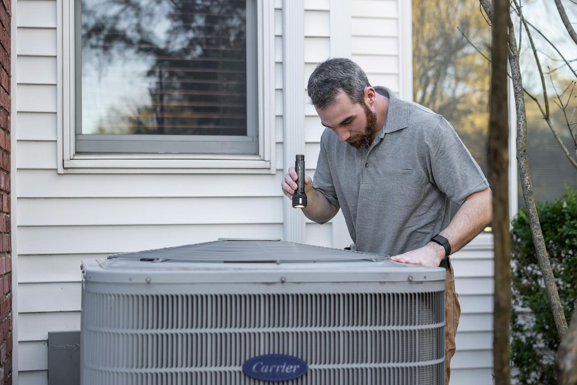 HVAC technician working on an outdoor condenser unit